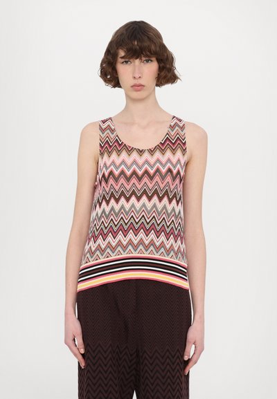 Top bez rukávů s multicolor zigzagovým vzorem v růžové, hnědé a krémové barvě, s proužkovaným žebrovaným lemem v černobílé barvě.