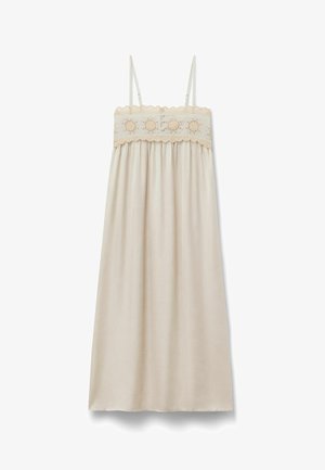 Ærmeløs beige kjole med tynde stropper, blomsterbroderi, knapdetaljer på brystet og et flydende skørt.