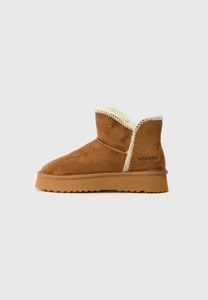Brown suede ankle boot with cream faux fur lining, scalloped edge, and rubber sole. Features "W" logo and contrast stitching.
