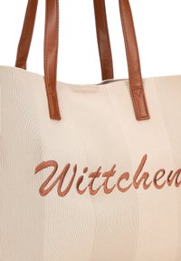 Beige gevlochten tote bag met gladde bruine leren handvatten. Heeft een geborduurd "Wittchen" in cursieve stijl aan de voorkant.