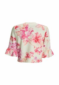 Blouse courte crème avec un grand imprimé floral rose et des manches courtes ornées de poignets volantés.