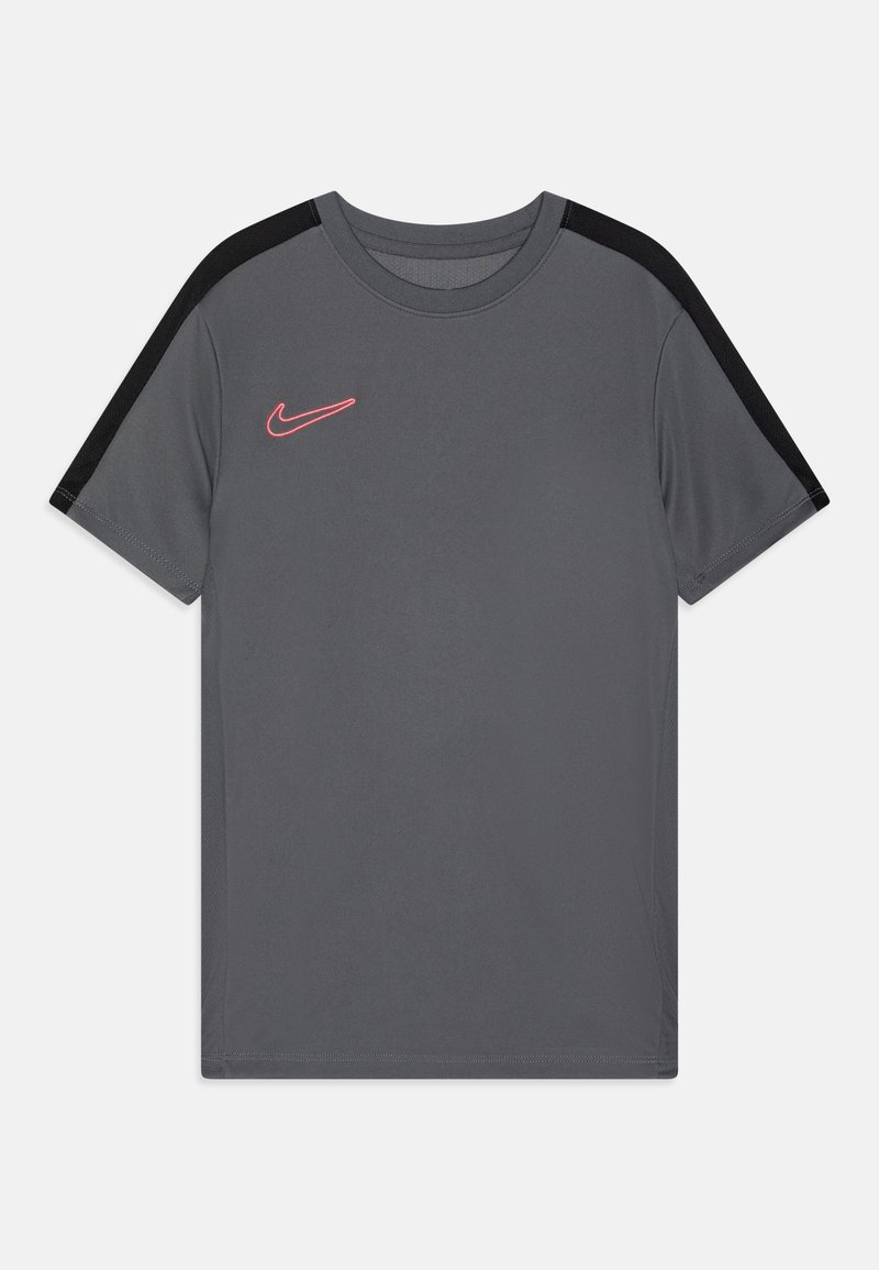 Camiseta atlética gris de mangas cortas, con acentos negros en los hombros y un logo de Nike rosa en el lado izquierdo del pecho. Textura de tela suave.