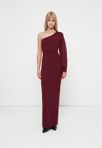 Burgundijas viena pleca maxi kleita ar pieguļošu augšdaļu un puffēta piedurkne. Gluda, elastīga auduma un pielāgota silueta elementi uzsver eleganci.
