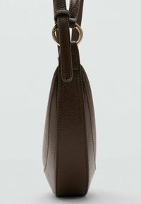 Brązowa skórzana torebka z teksturowanym wykończeniem, smukłym profilem i regulowanym paskiem z detalem w postaci złotego pierścienia.