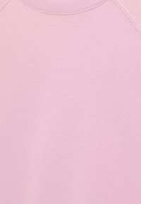 Tissu de sweat-shirt rose clair à col rond côtelé, montrant un matériau doux et un design simple et uni. Aucun logo ou motif visible.