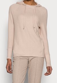 Rosa-beige hoodie med en avslappnad passform, featuring en justerbar huva, långa ärmar och ribbade mudd och nederkant. Mjukt tyg med en slät yta.