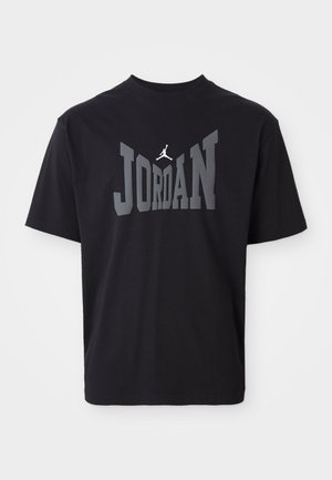Black cotton T-shirt featuring "JORDAN" in large gray letters with a jumpman logo in white above the text. Round neckline and short sleeves.