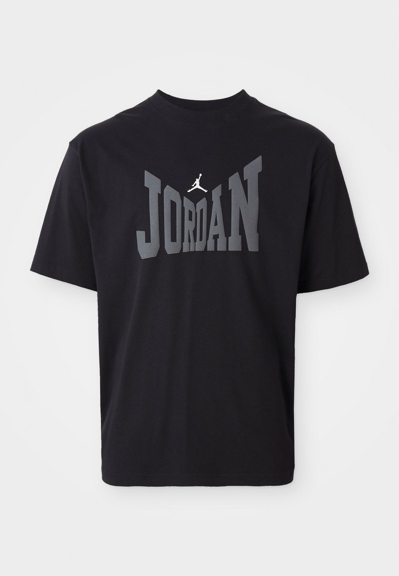 Czarny bawełniany T-shirt z dużym napisem "JORDAN" w szarym kolorze oraz logo jumpman w białym nad tekstem. Okrągły dekolt i krótkie rękawy.