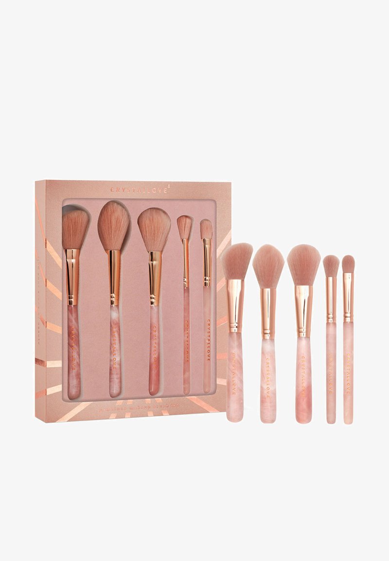 Zestaw ośmiu pędzli do makijażu z miękkim różowym włosiem, różowozłotymi skuwkami i jasnoróżowymi marmurkowymi rączkami, zaprezentowany w dekoracyjnym pudełku.