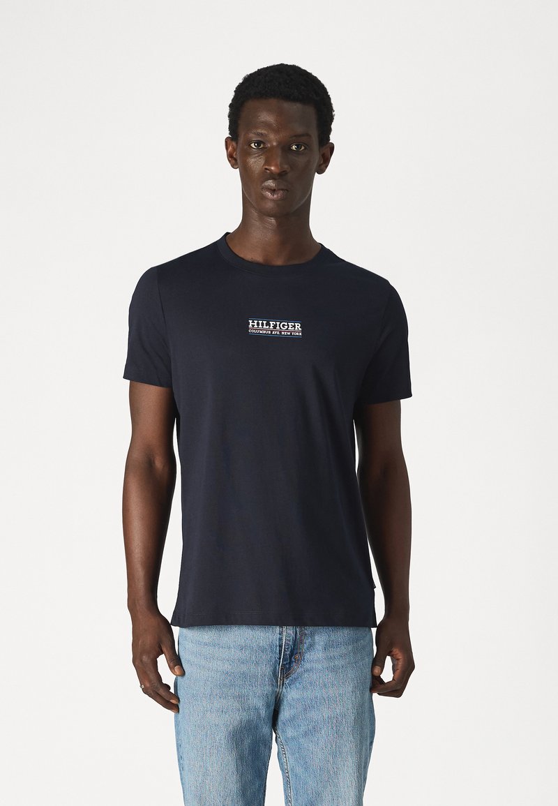 T-shirt da uomo in cotone blu navy con collo rotondo e maniche corte, con il logo "HILFIGER" ricamato in bianco sul petto.