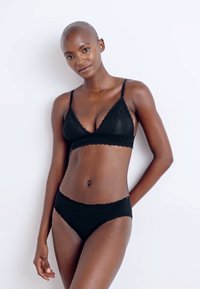 Black lace triangle bralette with scalloped edges and adjustable straps, paired with matching low-rise bikini underwear, both featuring a soft texture.