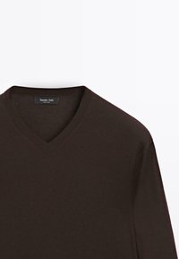 Brauner V-Ausschnitt-Pullover aus weichem Stoff, mit glatter Textur und geripptem Abschluss am Kragen. Etikett am Kragen sichtbar.