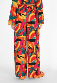 Kleurrijke wijde broek met een elastische tailleband, met een gedurfd bloemenpatroon in rood, oranje, groen en gele tinten.
