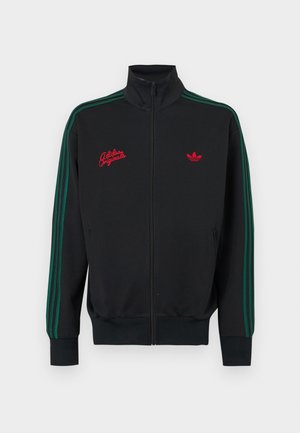 Czarna kurtka zapinana na zamek z zielonymi paskami po bokach, z czerwonym wyszywanym logo i napisem, wysokim kołnierzem oraz ściągaczami na mankietach i u dołu.