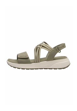 Lysebrun sandal med tyk hvid sål, justerbar frontrem og flettede sideremme for støtte, vist fra siden.