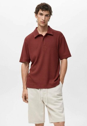 Burgundy short-sleeve polo shirt with ribbed texture and a three-button placket, paired with light beige shorts, displayed against a white background.