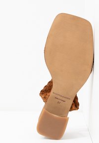 Semelle d'une sandale en cuir tressé couleur camel, marque Scotch & Soda, fabriquée au Portugal, taille 37, avec un bout de talon carré.