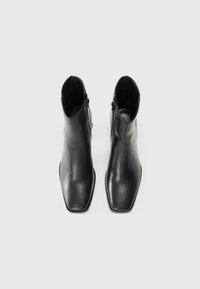 Black leather ankle boots with a sleek design, square toe, and side zippers, featuring a smooth texture and minimal stitching details.