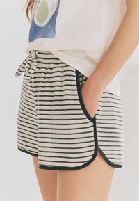 Randiga shorts i mjukt tyg, med ett svartvitt mönster, elastisk midja med snörning och sidofickor.
