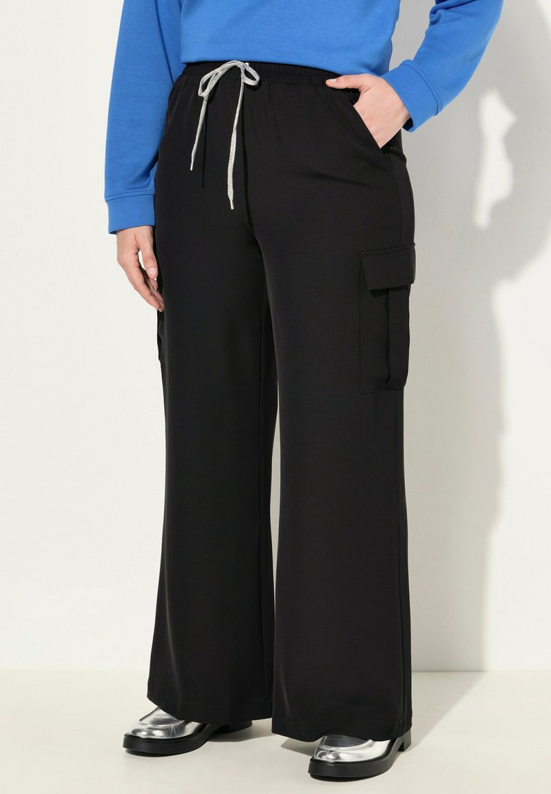 Zwarte cargo-broek met wijde pijpen, een elastische tailleband en grijze trekkoorden, met zijzakken en een gladde textuur.