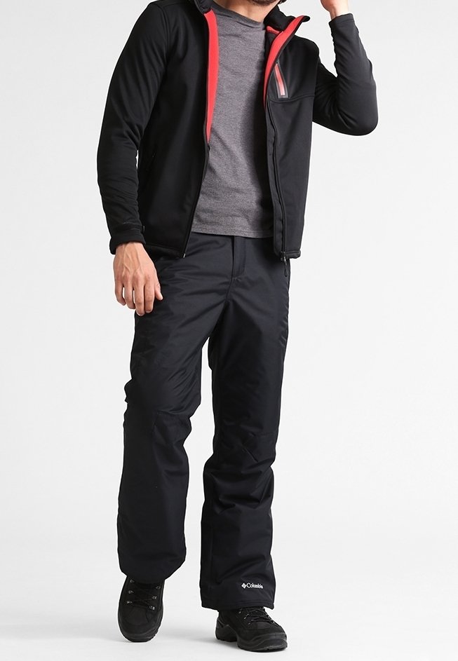 Chaqueta negra con cremallera y detalles rojos, camiseta gris por debajo, combinada con pantalones de nieve negros y calzado, adecuada para actividades invernales.