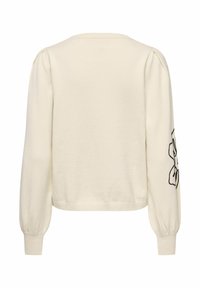 Kremfarget genser med puffede ermer, ribbet kant og mansjetter, med et svart blomsterdesign på venstre erme. Myk strikketekstur.