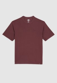 Burgundské tričko s krátkým rukávem a kulatým výstřihem s malým vyšitým logem na hrudi a značkovou etiketou u lemu, položené na šedém pozadí.