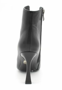 Czarne skórzane botki za kostkę o eleganckim designie, z wyd pointed toe oraz wysokim obcasem typu stiletto. Posiadają zamek błyskawiczny z boku i gładką teksturę.