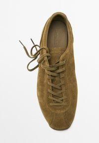 Brune ruskinds sneakers med rund tå, flade snørebånd og et minimalistisk design. Har syningsdetaljer og en glat inderside.