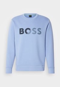 Light blue sweatshirt featuring a large, black "BOSS" logo with varying textures. Round neckline and ribbed cuffs. Smooth fabric finish.
