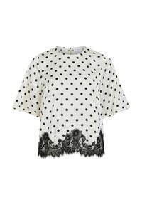 Blouse à pois blanc avec des pois noirs, manches courtes, encolure ronde et bordure en dentelle noire le long de l'ourlet inférieur. Texture de tissu lisse.