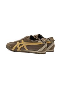 Brune lædersneakers med gule accenter og en tan gummisål. Har klassiske striber og en tekstureret hæl med logo-detaljer.