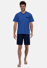 Blue patterned short-sleeve V-neck shirt with a chest pocket, paired with dark navy shorts, featuring a relaxed fit and soft fabric.