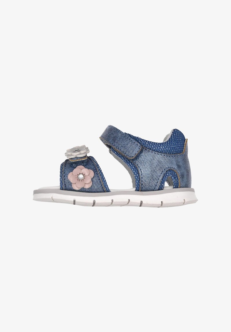 Sandale en denim avec des accents floraux en rose et gris, sangles Velcro, et semelle en caoutchouc blanc avec un relief texturé.