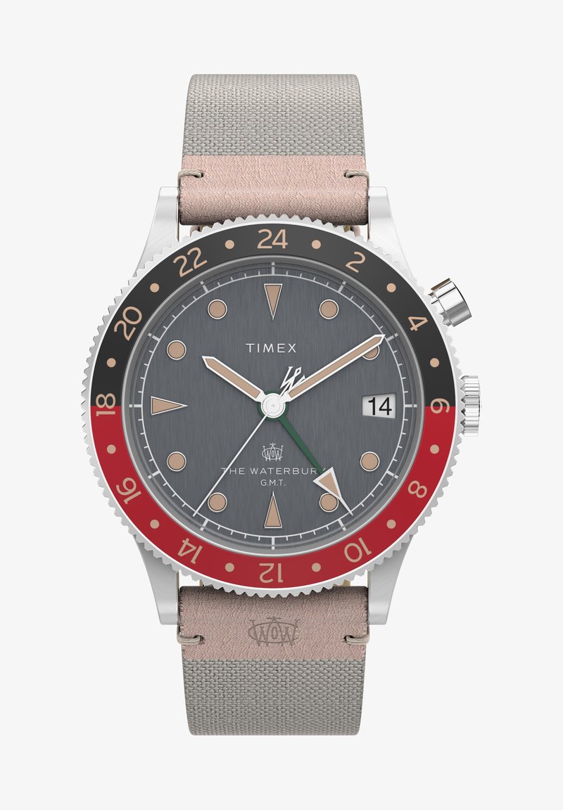 Sivi okrugli sat sa kućištem od nehrđajućeg čelika, crveno-crnom bezelu i sivom platnenom remenjem. Ima minimalističke oznake vremena i prozor za datum na 3 sata.