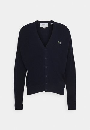 Cardigan navy in morbido tessuto, con scollo a V, maniche lunghe, sei bottoni e un piccolo logo verde sul petto.