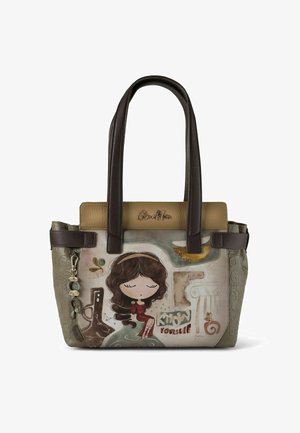 Bolso marrón y beige con ilustración de una niña de dibujos animados, lados texturizados, detalle de cadena y el logo "Anekke" en la parte superior del frente.