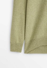 Grüner Strickpullover mit weicher Textur, ausgestattet mit einem gerippten Bund und Ärmelbündchen. Der Stoff zeigt ein dezentes Mischmuster.