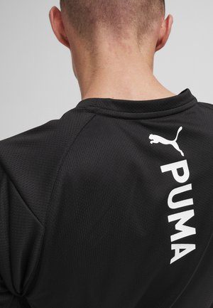 Zwarte sportshirt van textuurstof, met een witte "PUMA"-logo en een silhouet van een springende kat op de bovenrug.