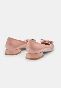 Balerini din piele patent roz, cu un călcâi mic, având o fundă decorativă pe fiecare pantof. Textură netedă, design cu vârful rotunjit.