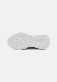 Baltas guminis batų padas su raštuotu paviršiumi, kuriame yra geometrinių formų, o šalia kulno įspaustas "LACOSTE" logotipas.