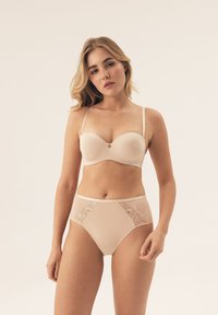 Beżowy biustonosz z usztywnianymi miseczkami i złotym akcentem, w zestawie z majtkami wysokim stanem z koronkowymi wstawkami po bokach. Miękka, gładka faktura.