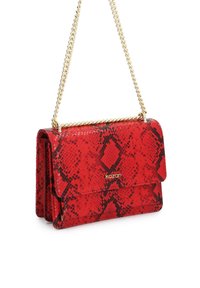 Červená kabelka cez rameno s hadím vzorom, zlatým retiazkovým popruhom a klopovým uzáverom, s logom "kazar" na prednej strane.