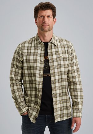 Groene en beige geruite flanellen overhemd met een knoopsluiting aan de voorkant, lange mouwen en een klein logo op de borst, gedragen over een zwart T-shirt.