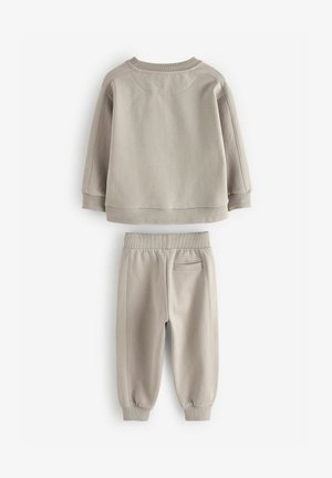 Sudadera gris claro y pantalones de chándal a juego. Tejido suave y texturizado con puños acanalados, cuello redondo y un sutil detalle de costura.