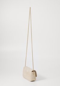 Borsa a spalla in suede beige con tracolla in catena dorata. Forma rettangolare con chiusura a patta, che mostra una texture morbida e un design minimalista.