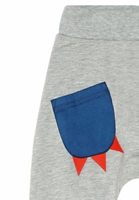 Graue Sweatpants mit einer blauen Tasche und roten dreieckigen Akzenten, aus weichem Stoff gefertigt und mit einem gerippten Bund.
