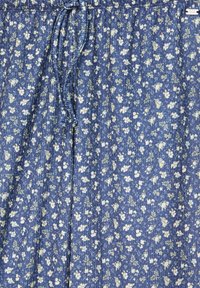 Modrá látka s květinovým vzorem obsahujícím bílé a žluté květy. Design zahrnuje vertikální sklady a elastický pas na šňůrku.