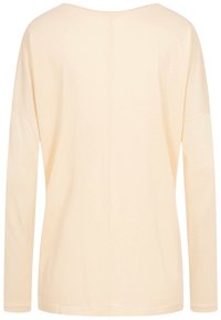 Långärmad topp i ljusbeige, mjukt bomullsmaterial. Har en avslappnad passform, vid halsringning och enkel design utan utsmyckningar.