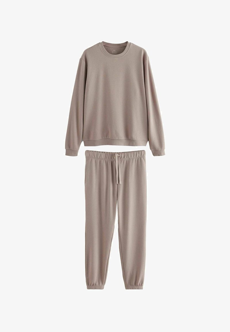 Vaffelstrikket afslapningssæt i lys taupe. Blusen med lange ærmer har en crew neckline, mens bukserne har en elastisk talje med snore.